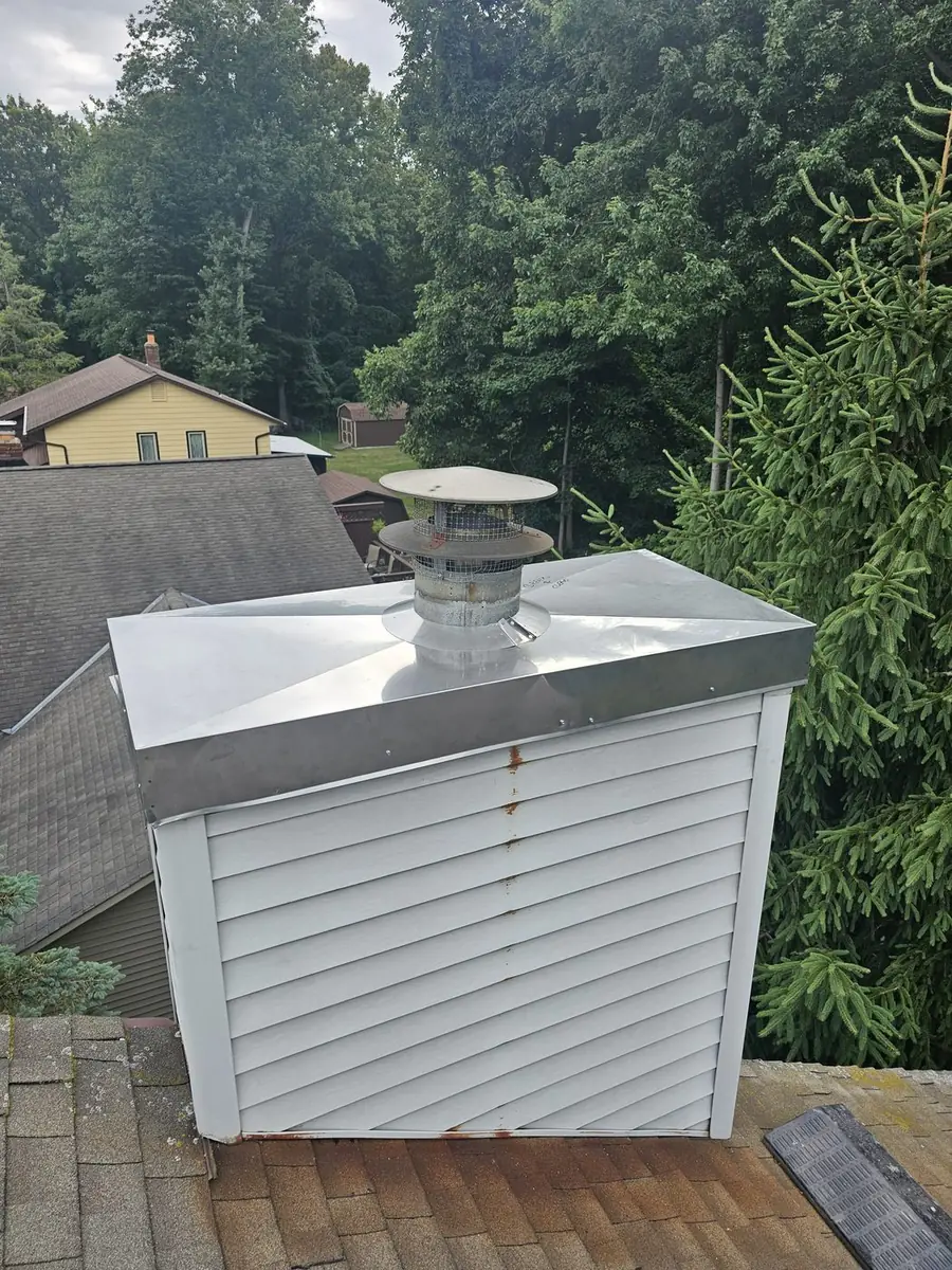 Green and Clean technician working on a chimney from the roof