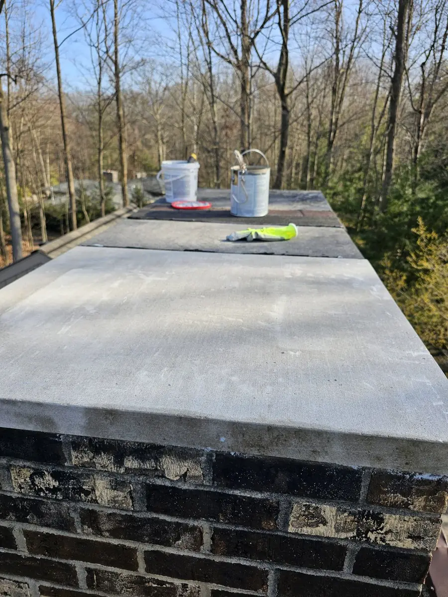 Technician working on chimney flashing at the roofline