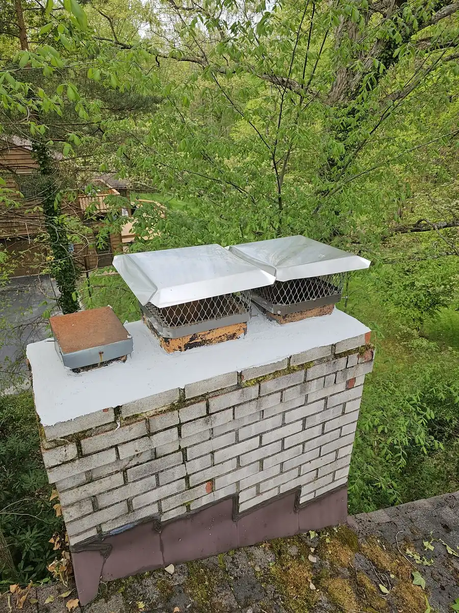 Green and Clean technician on a roof working at the base of a chimney