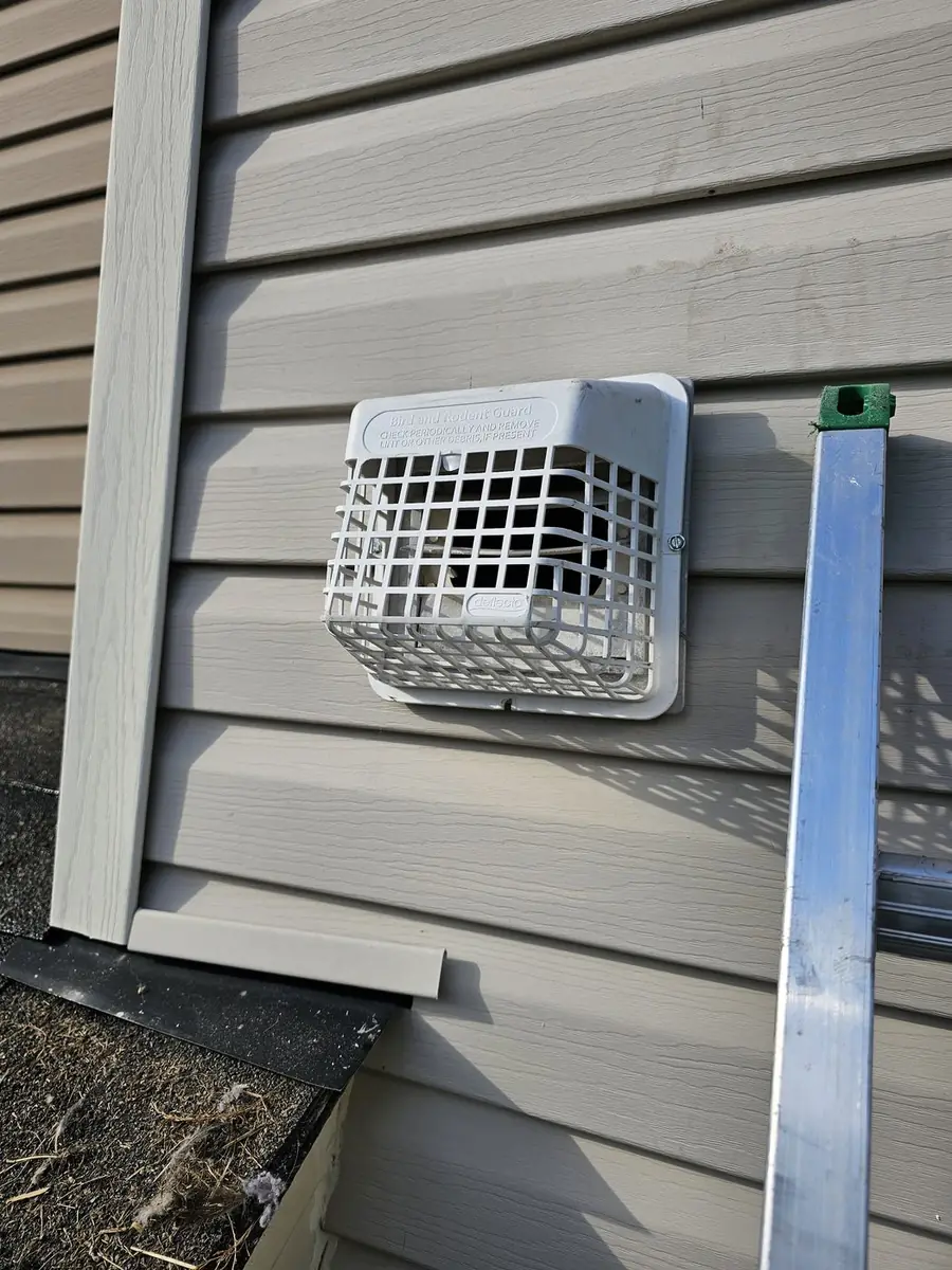 Green and Clean technician working on an exterior dryer vent