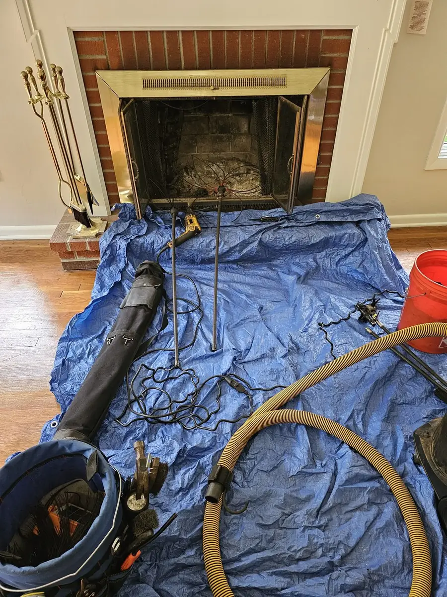Stone fireplace protected with drop cloths during a chimney sweep