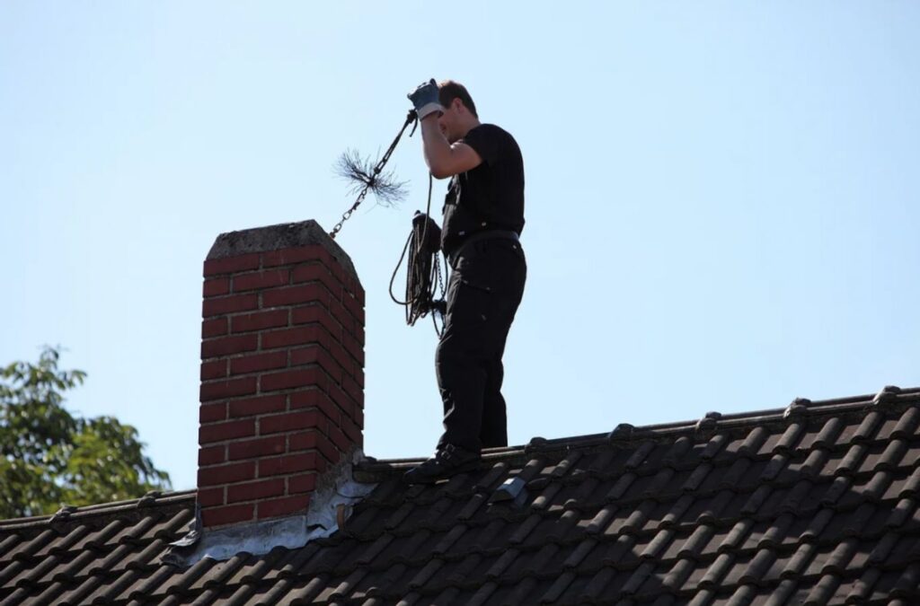 A Green and Clean Home Services technician removing soot and creosote from a chimney in Willoughby, Ohio.