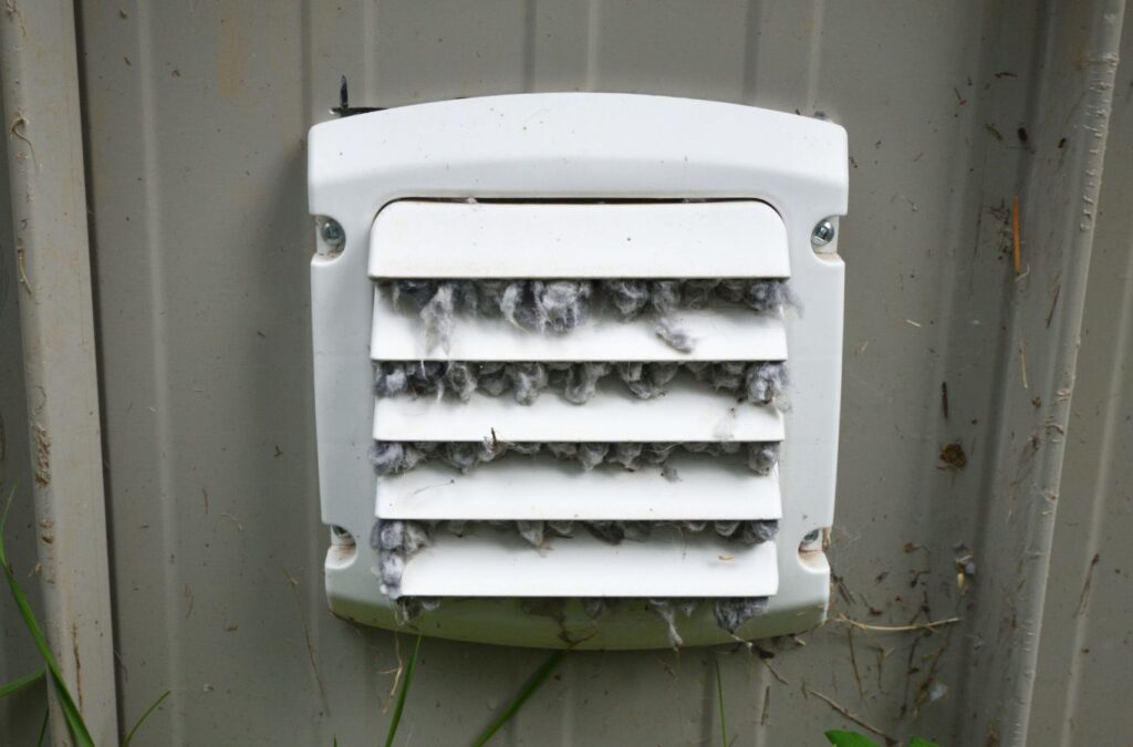 Green and Clean Home Services technician improving dryer efficiency by cleaning vents in Chardon, Ohio.