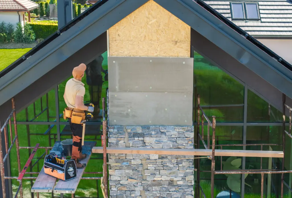 worker installing stone facade on residential buillding
